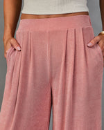 Dusty rose wide-leg pleated pants with side pockets and elastic waistband, paired with white ribbed crop top