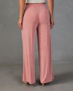 Dusty rose wide-leg palazzo pants with elastic waistband, satin finish, worn with nude heels, back view