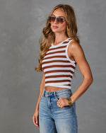 Woman wearing brown and white striped cropped knit tank top with light wash jeans, gold bangles, and aviator sunglasses