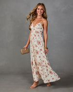 Cream floral maxi dress with pink roses, V-neck, spaghetti straps, tiered skirt, styled with strappy heels and rattan clutch