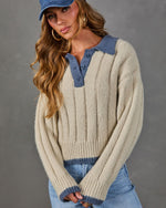 Cream ribbed knit polo sweater with blue contrast collar and trim, styled with a denim cap, gold hoops and light-wash jeans