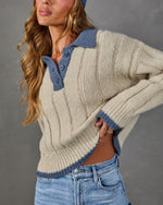 Cream ribbed knit polo sweater with blue contrast collar and trim, styled with light wash high-waisted jeans and a blue headscarf