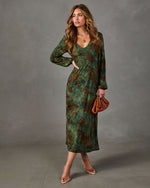 Green floral midi dress with long balloon sleeves and V-neckline, styled with a rust leather clutch and clear heels
