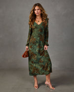 Green floral long-sleeve midi dress with V-neckline, styled with tan clear-strap heels and a brown leather clutch