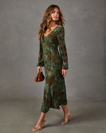 Green floral long-sleeve midi dress with V-neckline, styled with brown clutch and clear-strap nude heeled sandals