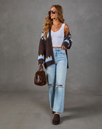 Woman in brown Fair Isle cardigan, white ribbed crop tank, light wash ripped wide-leg jeans, fuzzy brown bag and platform boots