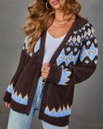 Brown Fair Isle cardigan with blue and cream patterned yoke, open front, worn over white ribbed top and light-wash jeans