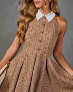 Sleeveless tweed fit-and-flare dress with white collar, gold knot buttons, and pleated skirt in warm camel tones