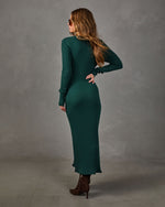 Woman in a green ribbed knit midi sweater dress with long sleeves, styled with brown suede heeled ankle boots and sunglasses