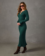 Woman in a green ribbed knit long-sleeve henley midi dress with brown suede heeled ankle boots and aviator sunglasses