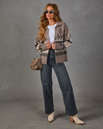 Woman in a taupe Fair Isle zip-up cardigan, white tee, gray wide-leg jeans, cream western ankle boots and suede shoulder bag