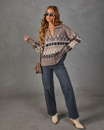 Woman in a taupe Fair Isle zip-up sweater, wide-leg gray jeans, cream ankle boots, sunglasses and a suede crossbody bag