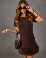 Brown knit mini dress with faux fur hem, styled with gold cuff bracelets, tortoiseshell sunglasses and a woven leather bag