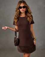 Brown knit short-sleeve mini dress with faux fur hem, styled with tortoiseshell sunglasses, gold bangles and woven crossbody bag