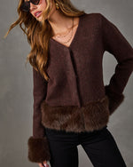 Brown knit cardigan with faux fur trim on hem and cuffs, styled with black pants, layered gold necklaces and sunglasses