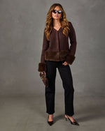 Brown V-neck cardigan with faux fur trim at hem and cuffs, styled with black straight-leg jeans, heels and a brown clutch