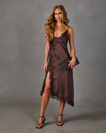 Chocolate brown satin midi slip dress with lace trim and side slit, styled with strappy heels and a brown textured clutch
