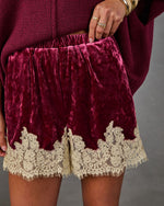 Burgundy crushed velvet shorts with cream floral lace hem and elastic waist, styled with an oversized knit sweater