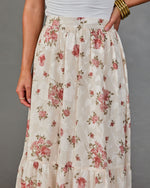 Cream floral maxi skirt with pink roses, tiered ruffle hem, elastic waistband, paired with white top and gold bangles