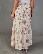 Cream floral tiered maxi skirt with pink roses, paired with white top and gold bangles, back view