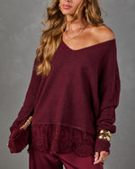 Burgundy V-neck sweater with lace hem, styled with gold bangles, layered necklaces and a matching suede clutch