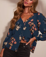 Navy blue floral print long-sleeve button-front blouse with pink blooms, styled with dark jeans
