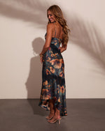 Floral satin high-low maxi dress with lace trim and spaghetti straps, worn with nude heels, back view