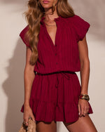 Crimson striped mini romper with ruffle neckline, flutter sleeves, drawstring waist, and tiered skirt hem on model
