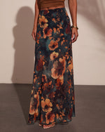 Floral maxi skirt in dark teal with rust orange blooms, paired with brown crop top and gold bangle bracelet
