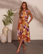 Sleeveless floral midi dress with orange and purple blooms, tie waist, front slit, worn with strappy heels