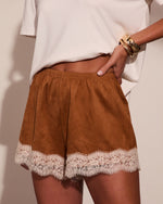Brown suede shorts with cream lace trim hem, elastic waist, styled with white tee and gold cuff bracelet