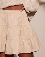 Cream corduroy tiered mini skirt with elastic waistband, paired with ivory chunky knit crop sweater