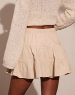 Cream corduroy tiered mini skirt with elastic waist, paired with chunky knit sweater, neutral tones