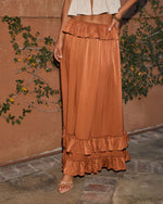 Copper satin maxi skirt with tiered ruffle hem and elastic waist, styled with cream crop top and strappy heels