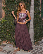 Woman wearing purple floral ruched crop top and mauve tiered maxi skirt with strappy heels and sunglasses outdoors