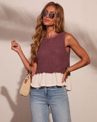 Woman wearing mauve crochet knit tank top with cream ruffle hem, light wash jeans, wicker bag, and gold bangles