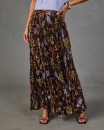 Brown pleated maxi skirt with blue and yellow floral print, styled with a lavender knit top and strappy sandals