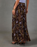 Brown pleated maxi skirt with blue and gold floral print, styled with a lavender top, gold cuff bracelet and strappy heels