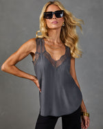 Gray lace-trim satin camisole top on blonde model with gold jewelry, black sunglasses, and black pants