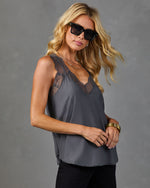 Gray lace-trim V-neck satin camisole top styled with black jeans, gold bangles, layered necklaces, and oversized sunglasses