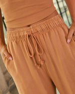 Terracotta drawstring jogger pants with elastic waistband and matching ribbed crop top, women's loungewear set