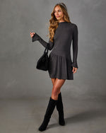 Charcoal gray long sleeve mini dress with bell cuffs and drop waist ruffle skirt, styled with black suede knee-high boots