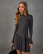Charcoal gray long sleeve mini dress with asymmetric drop waist, flared cuffs and mock neck, styled with a tweed headband