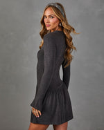 Charcoal gray long sleeve mini dress with drop waist ruffle skirt and flared cuffs, styled with a herringbone headband