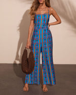 Blue floral stripe wide-leg jumpsuit with spaghetti straps, red flower print, worn with woven tote bag and sandals