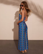Blue floral stripe wide-leg jumpsuit with open back, spaghetti straps, and smocked waist on woman model