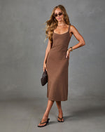 Brown ribbed midi dress on woman with spaghetti straps, styled with black heeled sandals, sunglasses, gold jewelry, and dark clutch.