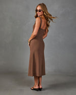 Brown sleeveless midi dress with open back, worn by woman with sunglasses and gold bangles, styled with black heels