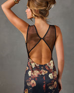 Floral satin maxi dress with sheer mesh open back and black trim, styled with gold cuff, hoop earring and claw clip