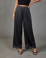 Black satin wide-leg pants with floral lace trim hem, paired with black heels and crop top, women's fashion